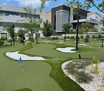 image of multiple putting green golf facility outside of Top Golf entertainment complex